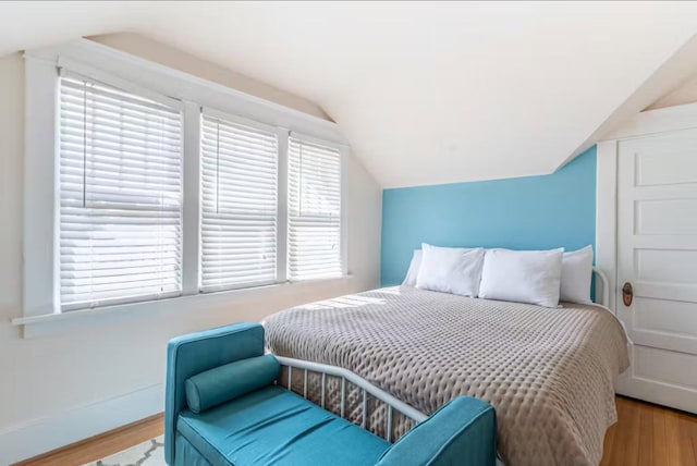 1046 3rd Ave E, Kalispell, MT 59901 - bedroom with wood finished floors, vaulted ceiling, and multiple windows