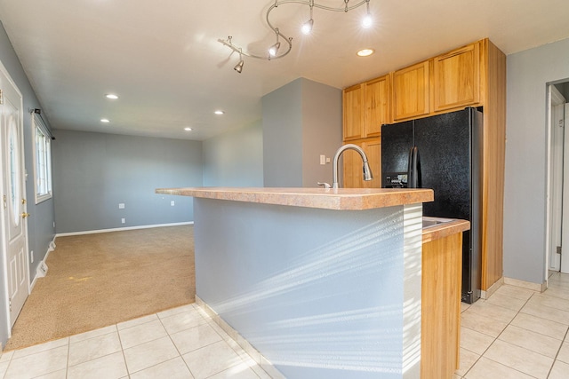 408 23rd Ave NE, Great Falls, MT 59404 - kitchen featuring light tile patterned floors, recessed lighting, light carpet, black fridge, and a kitchen island with sink