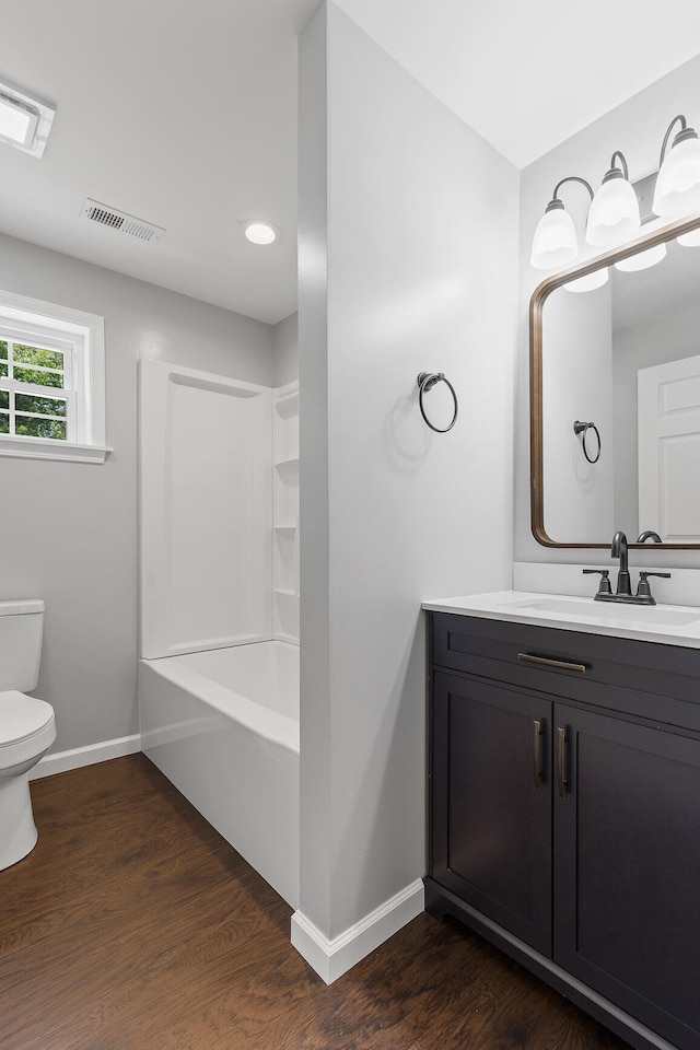 full bathroom with hardwood / wood-style flooring, vanity, toilet, and tub / shower combination