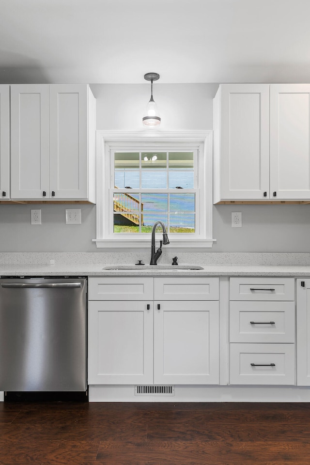 kitchen featuring pendant lighting, dishwasher, dark wood-type flooring, sink, and white cabinetry