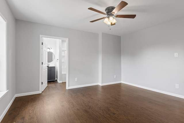 empty room with ceiling fan and dark hardwood / wood-style flooring