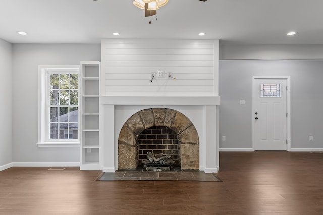 unfurnished living room featuring dark hardwood / wood-style floors, ceiling fan, and a fireplace