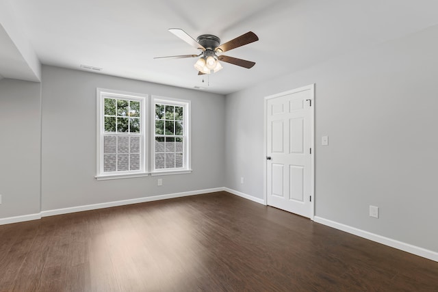 empty room with ceiling fan and dark hardwood / wood-style floors