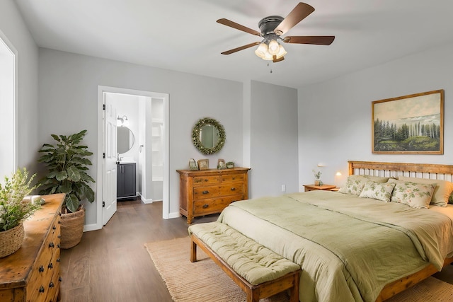 bedroom with ensuite bathroom, ceiling fan, and dark wood-type flooring