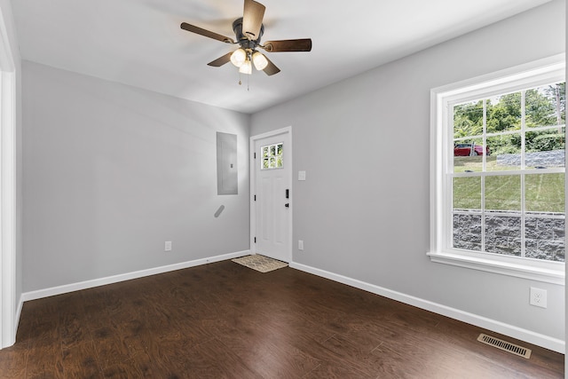 interior space with electric panel, plenty of natural light, dark wood-type flooring, and ceiling fan