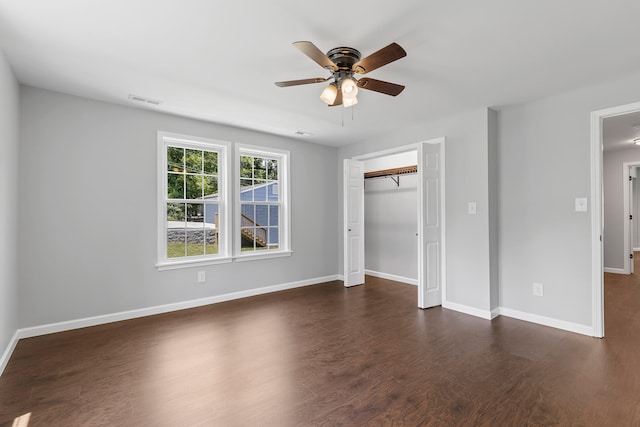 unfurnished bedroom with a closet, dark hardwood / wood-style floors, and ceiling fan