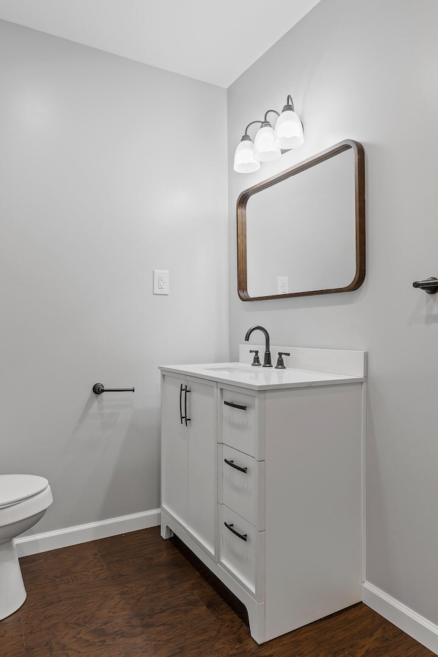 bathroom featuring vanity, hardwood / wood-style flooring, and toilet