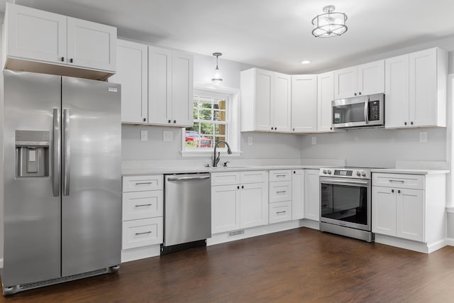 kitchen featuring white cabinets, decorative light fixtures, sink, and stainless steel appliances