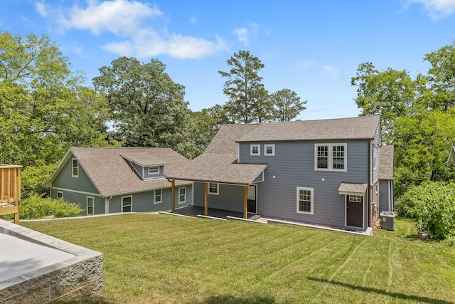 back of house featuring a lawn and central AC