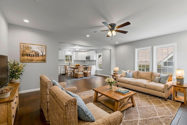 living room with ceiling fan, dark hardwood / wood-style flooring, and sink