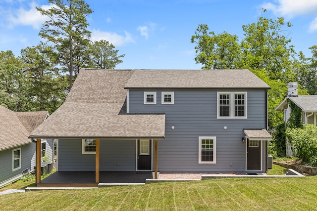 rear view of property with a yard and central AC