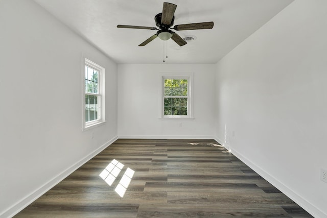 empty room with ceiling fan, dark wood-type flooring, and a healthy amount of sunlight