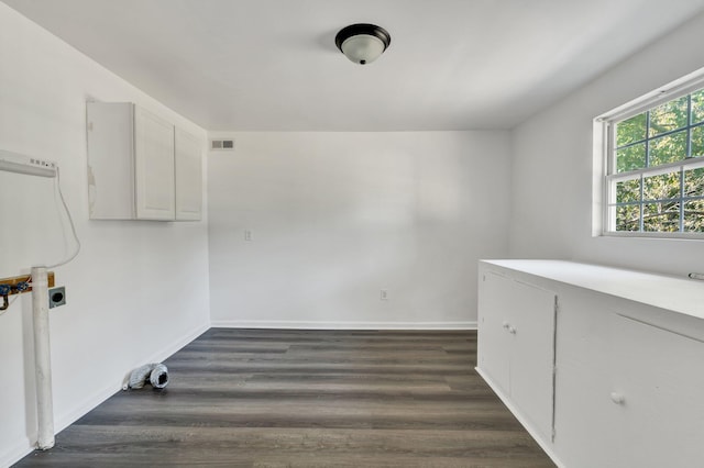 laundry room with electric dryer hookup and dark hardwood / wood-style flooring