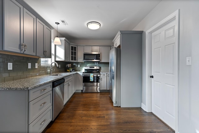 kitchen featuring sink, appliances with stainless steel finishes, gray cabinetry, hanging light fixtures, and light stone countertops