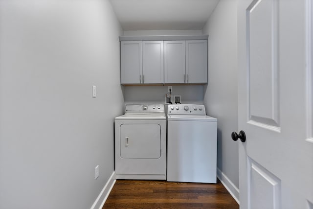 clothes washing area featuring cabinets, dark hardwood / wood-style floors, and washer and clothes dryer