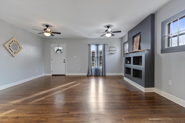 unfurnished living room featuring ceiling fan and dark hardwood / wood-style flooring