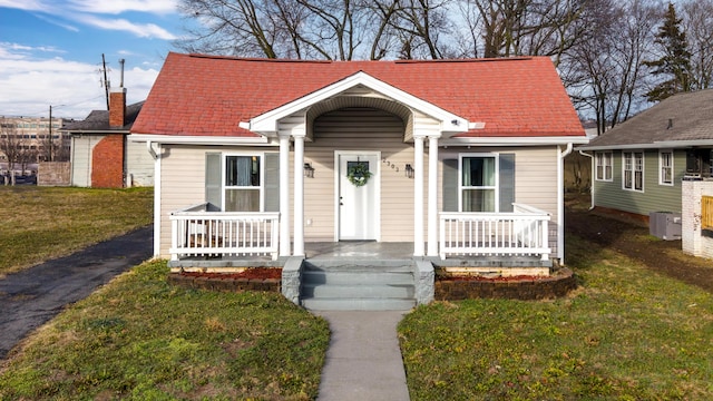 bungalow-style house featuring central AC, a front lawn, and a porch