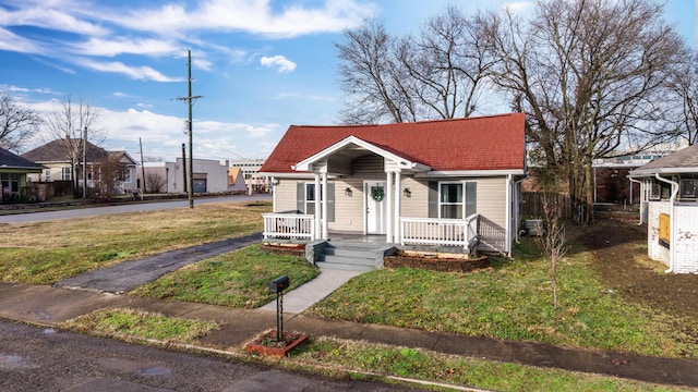 bungalow-style house featuring a front yard and covered porch