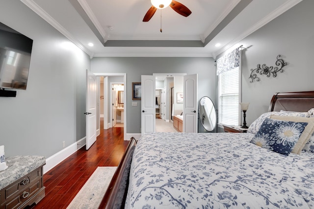 bedroom featuring recessed lighting, a tray ceiling, baseboards, ornamental molding, and dark wood finished floors