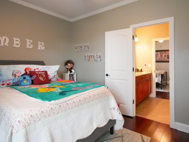 bedroom with crown molding and dark wood finished floors