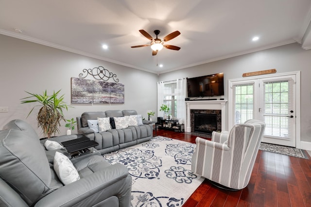 living area with wood finished floors, a healthy amount of sunlight, and a ceiling fan