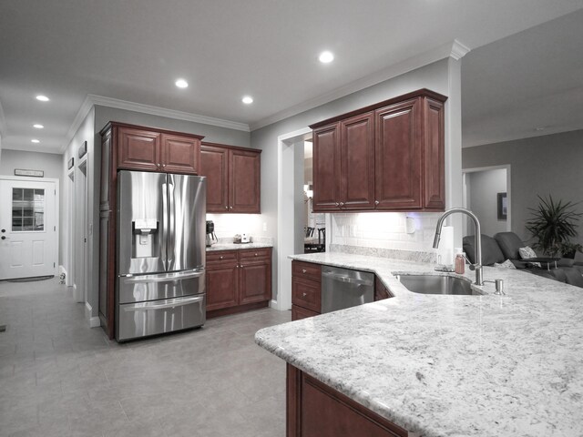 kitchen with stainless steel appliances, a peninsula, a sink, and a kitchen breakfast bar