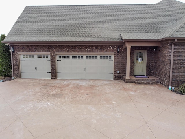 view of front of house with brick siding, driveway, an attached garage, and roof with shingles