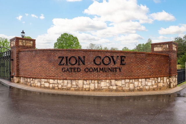 community / neighborhood sign featuring fence