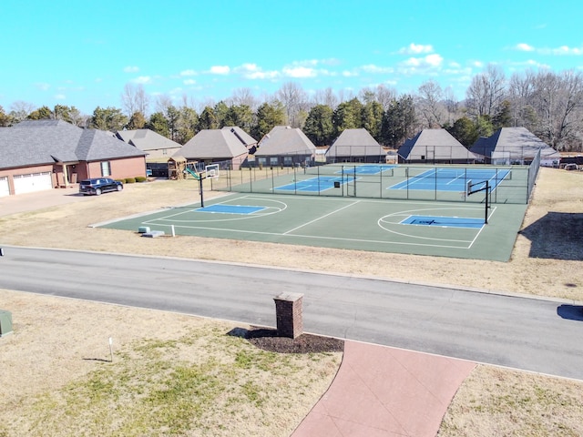 view of sport court featuring a tennis court and fence