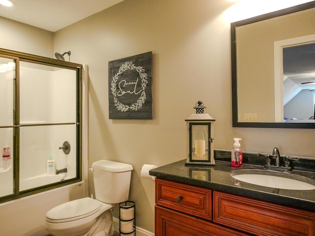 bathroom with enclosed tub / shower combo, vanity, and toilet