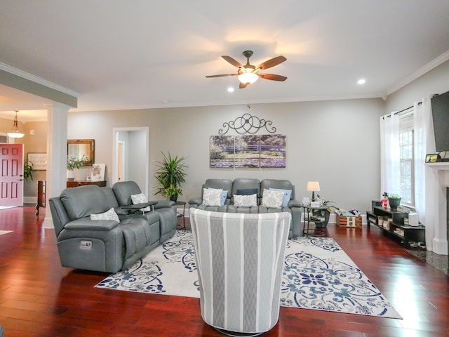 living area featuring ornamental molding, wood finished floors, and ornate columns