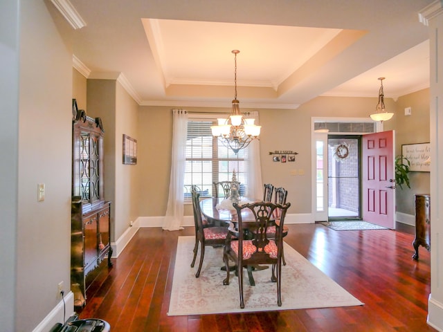 dining area with dark wood-style floors, a raised ceiling, crown molding, and baseboards