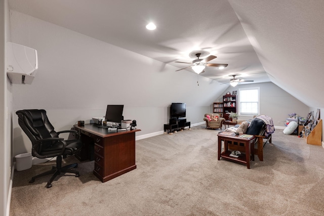 office space featuring a ceiling fan, baseboards, vaulted ceiling, light carpet, and a wall mounted air conditioner