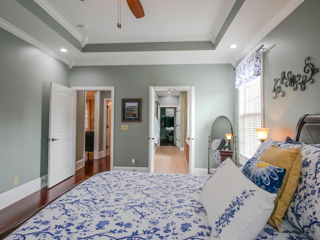 bedroom with baseboards, a tray ceiling, and crown molding