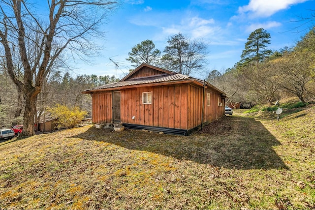 view of home's exterior featuring metal roof, a yard, and board and batten siding