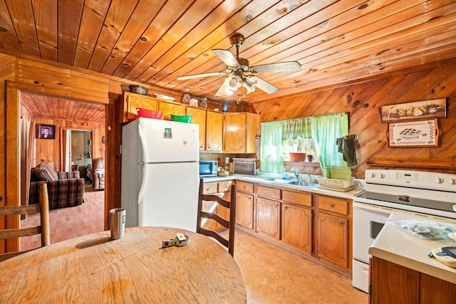 kitchen featuring wood walls, light countertops, wooden ceiling, white appliances, and a sink