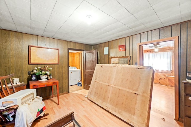 interior space featuring washer / dryer, light wood-style flooring, and wooden walls