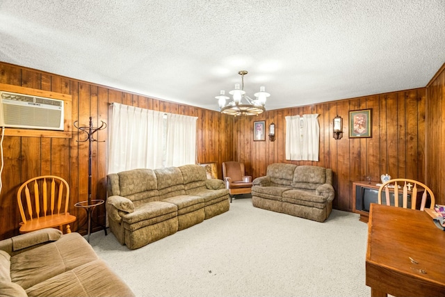 living area with wood walls, an AC wall unit, carpet flooring, an inviting chandelier, and a textured ceiling