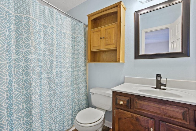 bathroom featuring toilet, vanity, and a shower with curtain