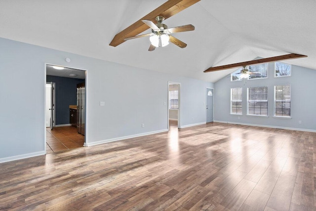 unfurnished living room with a ceiling fan, vaulted ceiling with beams, wood finished floors, and baseboards