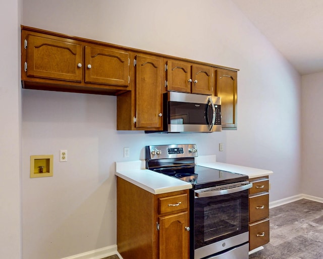 519 Cedar Glen Cir, Chattanooga, TN 37412 - kitchen with appliances with stainless steel finishes, brown cabinetry, light countertops, baseboards, and vaulted ceiling