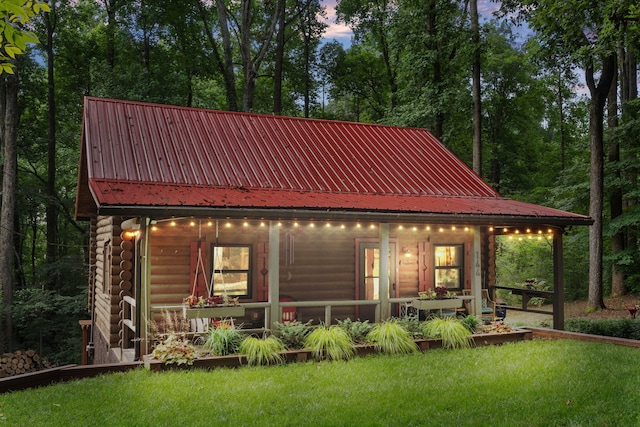 144 Low Brook Ct NE, Cleveland, TN 37312 - back of property at dusk with a lawn, a metal roof, and log exterior