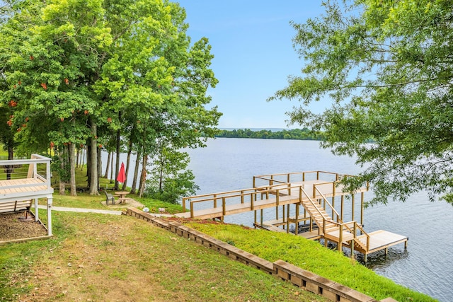 view of dock featuring a lawn and a water view