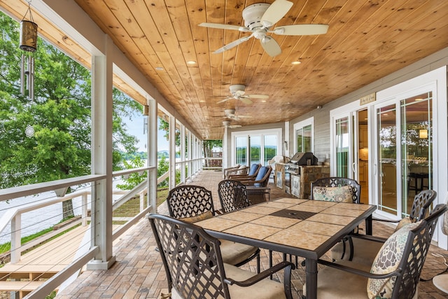 sunroom with ceiling fan and wood ceiling