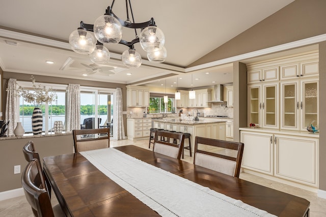 dining area with crown molding, light tile patterned floors, and lofted ceiling