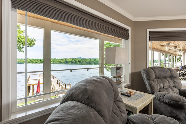 living room with plenty of natural light, a water view, and crown molding