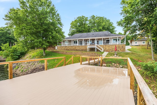 rear view of house featuring a deck and a lawn