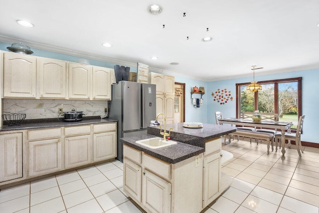 kitchen with sink, a kitchen island with sink, pendant lighting, decorative backsplash, and light tile patterned floors