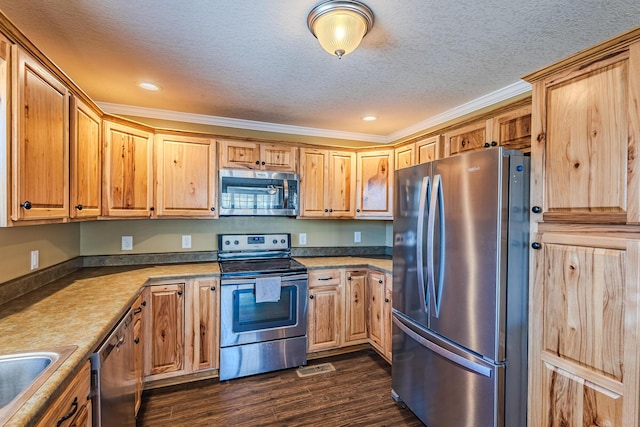 kitchen with appliances with stainless steel finishes, sink, crown molding, dark wood-type flooring, and a textured ceiling