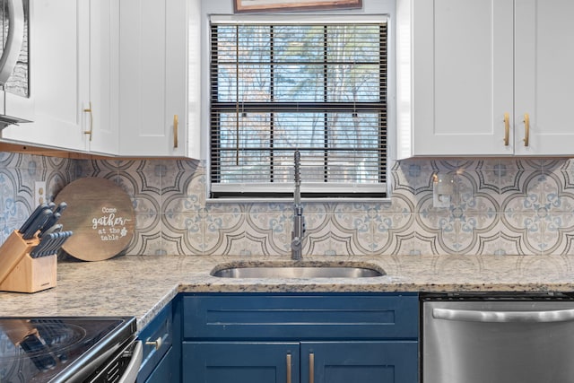 kitchen with blue cabinets, white cabinetry, a sink, and stainless steel dishwasher